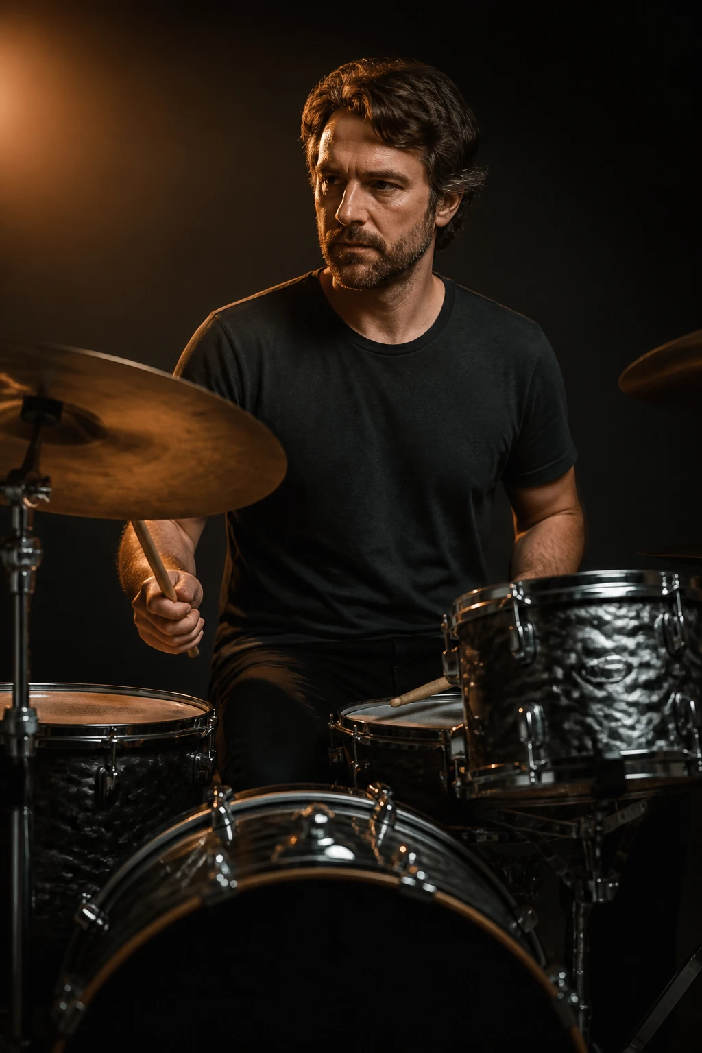 Retrato de um baterista adulto sentado atrás da bateria com baquetas nas mãos, luz quente lateral, fundo escuro