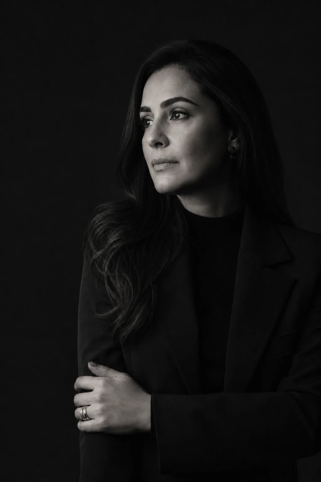 Retrato editorial em preto e branco de alto contraste da Dra. Beatriz Monteiro, em luz baixa, olhar sereno e composto.